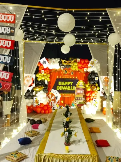 A grand canopy setup for a casino-themed Diwali party, with fairy lights, drapes, and a long table for guests.