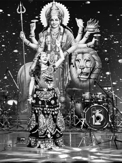 A powerful black and white shot from a Navratri event, capturing the divine energy of the festival on stage.