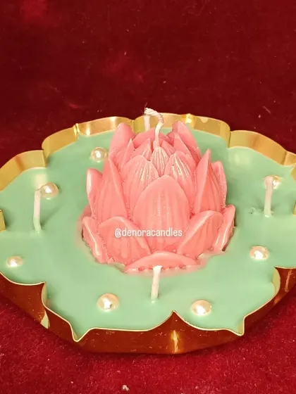 This beautiful lotus flower urli candle is handcrafted with a pink lotus centerpiece on a bed of green soy wax, accented with pearl details. It's a stunning piece for festive decor, infused with a lovely mogra fragrance.