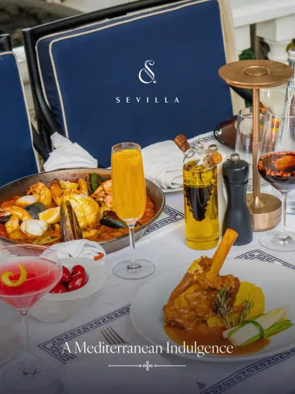 A Mediterranean indulgence. This table features our lamb shank, seafood paella, and colorful cocktails, showcasing a complete fine dining experience.
