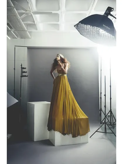 Another angle of the golden gown, showing the behind-the-scenes lighting. The styling is consistent, but the context changes, offering a different perspective.