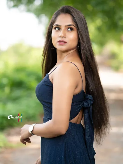 A full-length shot of a model in a navy blue dress, showing a confident and stylish pose.