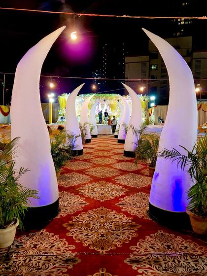 For a unique and majestic walkway, I offer these inflatable elephant tusk pillars. They are internally lit with customizable colored lights and create a dramatic, arched pathway leading to your stage.