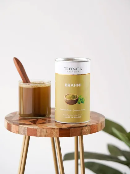 A minimalist shot of Brahmi powder, an Ayurvedic memory enhancer, styled with a wooden stool to give it an earthy, organic feel.
