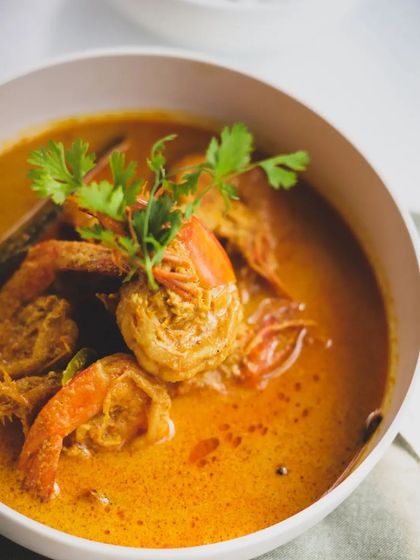 Close-up of our fragrant prawn curry. You can almost smell the coconut, turmeric, and fresh coriander. A truly immersive culinary experience.