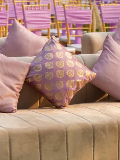 A close-up of the plush cushions on the lounge sofas, mixing solid pastels with traditional brocade patterns for a touch of texture and elegance.