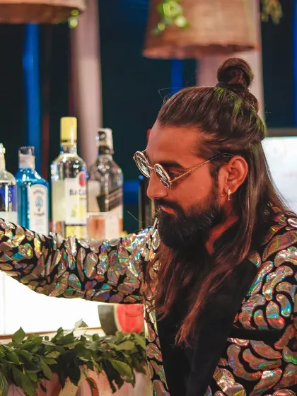 Mixing beats and drinks. My flashy jacket and focused expression show my dual role as both a performer and a master mixologist.
