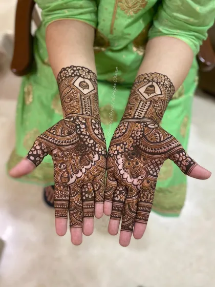 A beautiful mehendi design for the groom's mother. The patterns are intricate and feature a temple bell motif, adding a touch of tradition.
