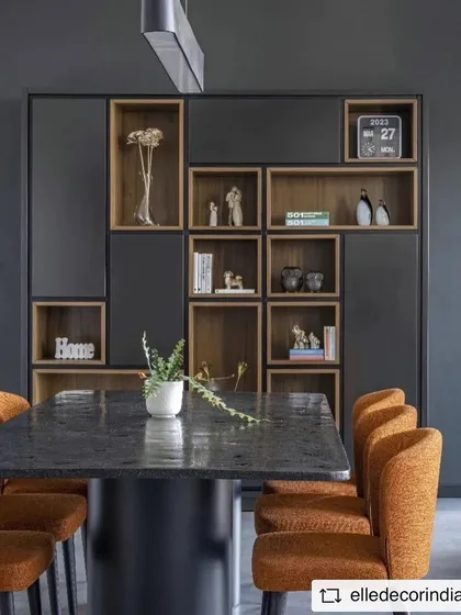 The dining area features a custom-designed table and a bespoke shelving unit. The open-backed shelves provide display space without adding visual weight, maintaining the room's airy and minimalist feel.