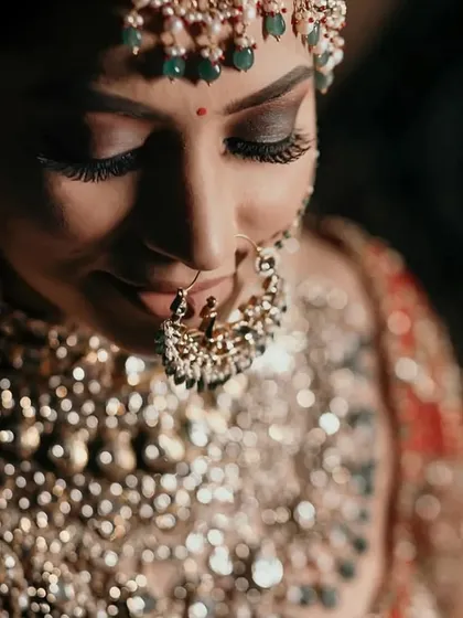 A detailed close-up of a bride's makeup, focusing on her stunning eye makeup and traditional nath (nose ring).