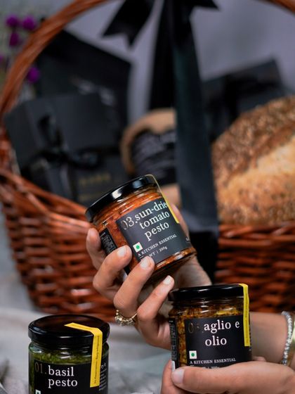 We believe in making gifting effortless. This wicker basket hamper is filled with our kitchen essentials, including sun-dried tomato pesto, aglio e olio, and freshly baked bread.