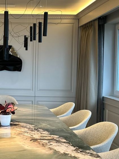 The sculpture holds its own next to the dramatic window and modern lighting.