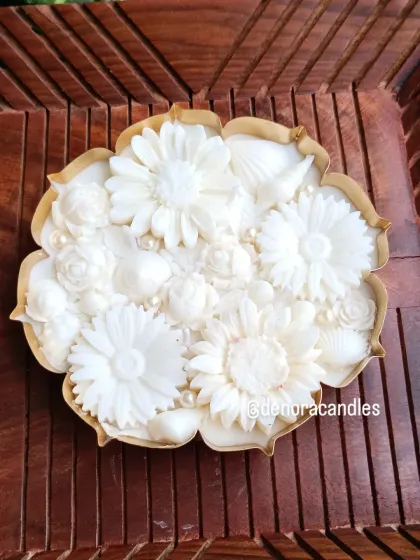 A top-down view of the all-white floral urli candle, showing the dense arrangement of different flower types.