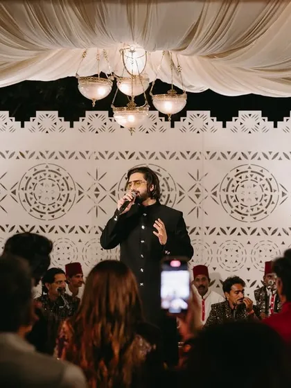 A guest of honor takes the stage to sing during the Sufi night, adding a personal and memorable touch to the evening's celebrations.