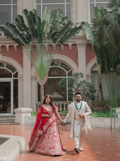 The couple walks hand-in-hand against a backdrop of grand architecture, a perfect blend of romance and majestic scenery.