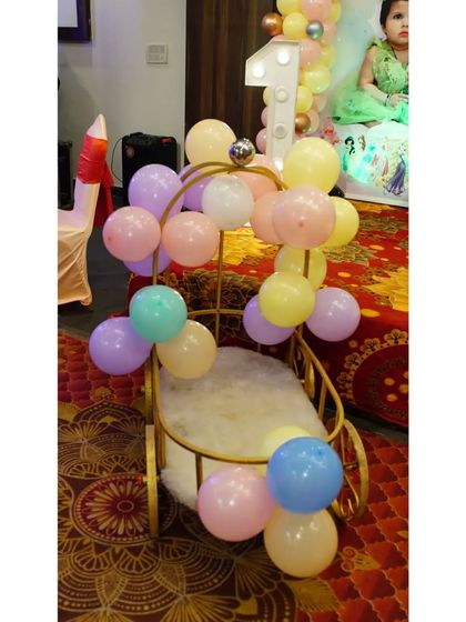 A princess needs her carriage! This adorable golden carriage seat, decorated with pastel balloons, was a special seating area for the birthday girl at her princess-themed party.