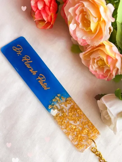 A bookmark is a thoughtful gift for any book lover. This one was made for a doctor, featuring his name in gold on a deep blue background with a gold leaf accent.