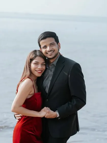 A happy portrait of the couple by the sea, their warm embrace and smiles reflecting the joy of their love story in the city.