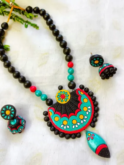 This version of the fan-shaped pendant necklace is in a cool teal, red, and black palette.