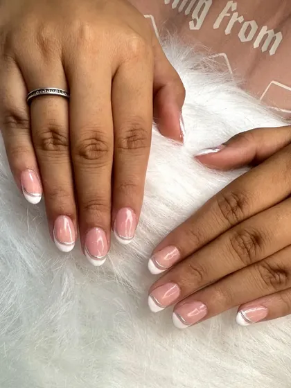 A perfect example of a classic French manicure with a silver chrome line, executed beautifully by a student.