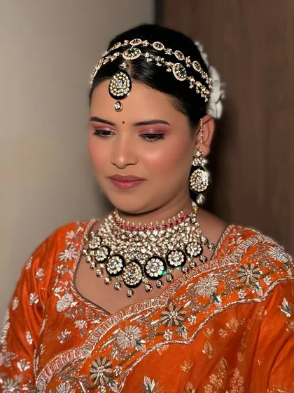 Who says brides have to wear red? Our stunning bride broke traditions in a vibrant orange lehenga, and we matched her energy with a radiant, luxe glam.