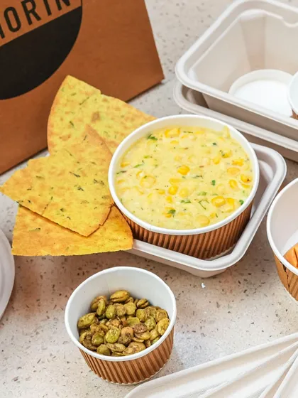 Comfort in a box. Our Sweet Corn Khichdi is delivered with crispy crackers and fried broad beans on the side, allowing you to add texture and crunch as you like.