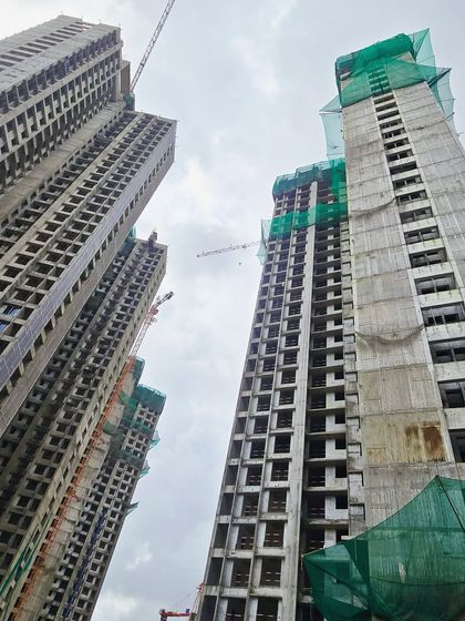 An upward-looking shot of the towers under construction, capturing the immense scale of this residential development.