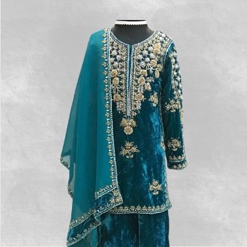 A luxurious teal velvet suit, custom-made for a winter wedding. The kurta is adorned with intricate gold and silver hand embroidery.