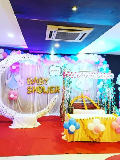 For a modern and fun baby shower, we design vibrant balloon-based decorations. This setup includes a custom crescent moon prop, balloon arches in pink, blue, and white, and cute baby-themed cutouts.