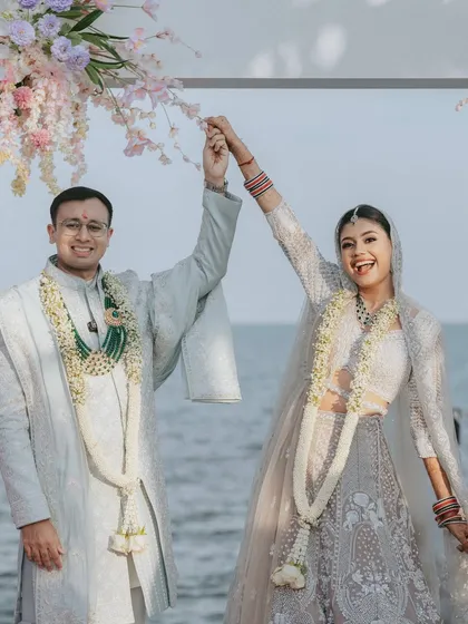 Just married, with the ocean behind them! This joyful shot captures the couple's happiness at their beautiful beachside mandap in Thailand.