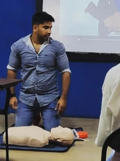 A look at our mandatory CPR and First Aid training. This is one of our trainers demonstrating the correct technique for chest compressions on a CPR manikin, a critical life-saving skill.