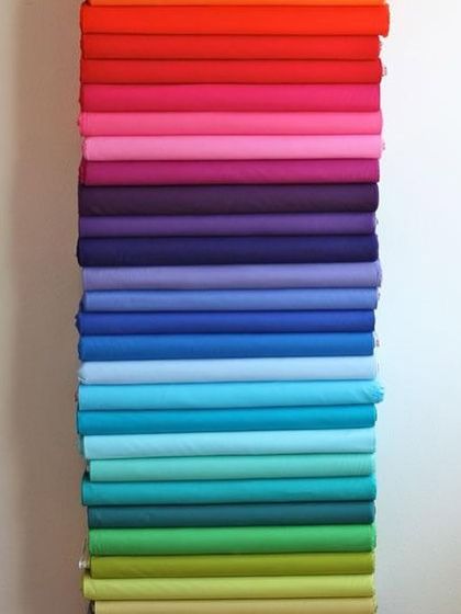 A rainbow of possibilities. This stack of colorful fabrics is ready to be transformed into your dream blouses, from bright oranges and pinks to cool blues and greens.