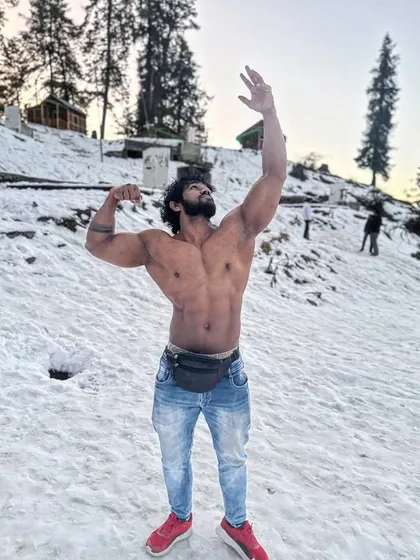 Taking the posing practice to the mountains. A classic pose against a snowy backdrop, showing that fitness is a lifestyle, not just a gym activity.