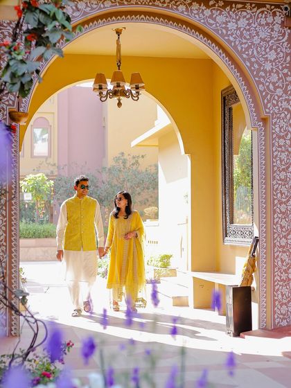 Another perspective of the couple walking through the sunlit corridor, showcasing the beautiful setting of their destination pre-wedding photography.