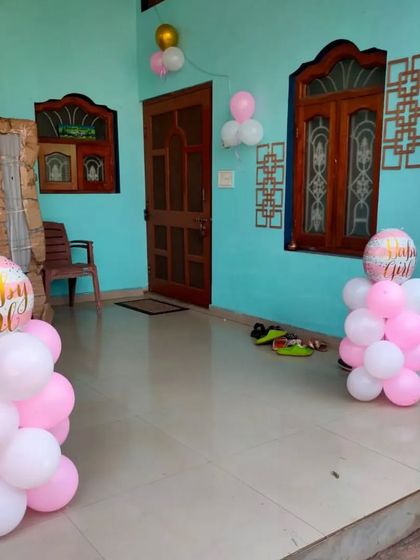 Simple outdoor balloon bunches in pink and white to welcome a baby girl.