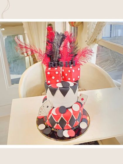 A glamorous casino-themed cake with dice, playing cards, and feathers, perfect for a high-stakes birthday party.