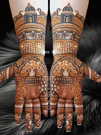 A majestic full-hand design featuring peacocks within jharokhas and grand domes on the wrists.