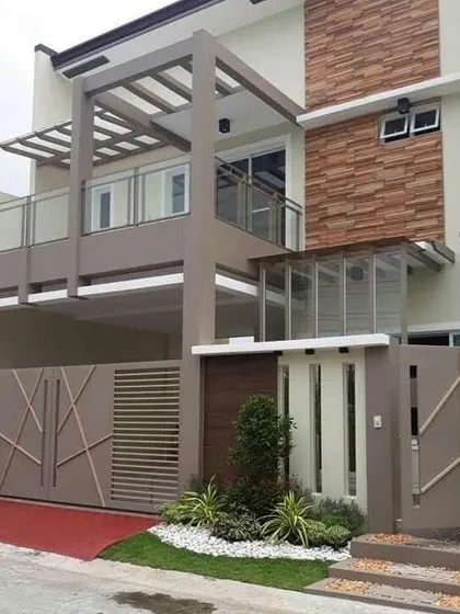This residential design uses a neutral color palette with stone cladding accents for a timeless look. The structure incorporates a second-floor balcony and a glass-enclosed section, balancing open and private spaces within the home's facade.