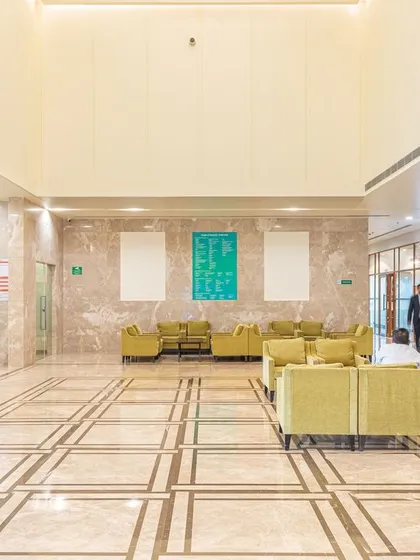 The lobby at Fortis Healthcare, a former hotel, was designed to be serene and inviting. The high ceilings and grand proportions are balanced with warm lighting and comfortable furniture to ensure a positive patient experience.
