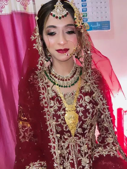 A close-up of this gorgeous bridal look. The combination of red, green, and gold is a classic choice for a traditional Nikah ceremony.