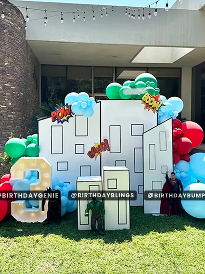 An outdoor superhero party with a cityscape backdrop made of white panels. I used "Pow!" and "Boom!" comic book exclamations and figures of Superman and Hulk to create a fun, action-packed scene.