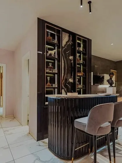 This home bar is designed as a sophisticated focal point. The back-lit panel with its dramatic stone pattern is the main feature, with integrated vertical lighting in the shelving to make the glassware and bottles glow.