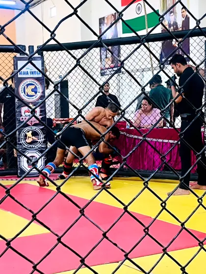 A glimpse into the grappling exchange during a competitive MMA match. Our fighter works to take his opponent down against the cage wall, showcasing the wrestling aspect of our training.