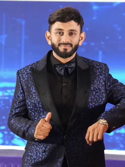 A moment of calm before the show starts. Dressed in a custom blue patterned tuxedo, I'm ready to take the stage. A sharp look is part of the professional package I bring to every event.