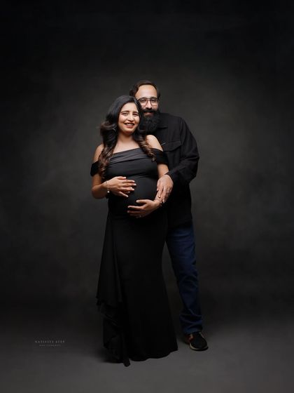 A classic couple's portrait in matching black outfits. The pose is formal yet intimate, perfect for a timeless keepsake.