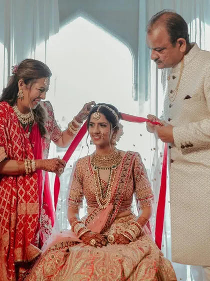 The bride's parents helping her with the final touches. A beautiful, intimate family moment before she walks down the aisle.
