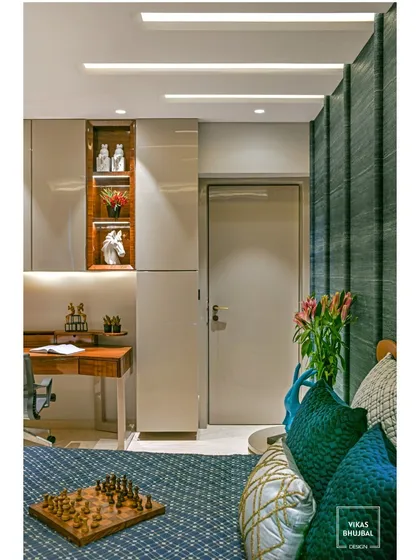 A different angle of the same bedroom, showing the integrated wardrobe and display niche. The clever use of lighting highlights decorative items and adds warmth to the room.