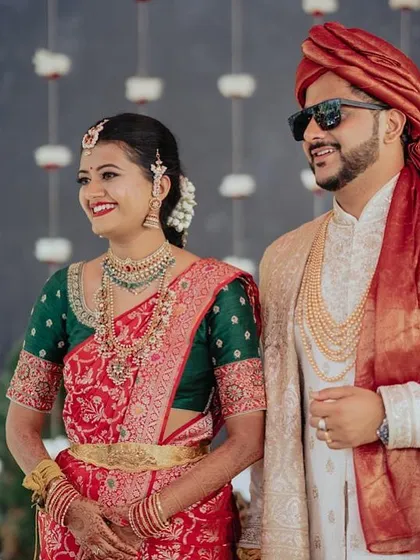 A happy couple. The bride wears a red and green saree with a custom embroidered green blouse, looking stylish and traditional at the same time.