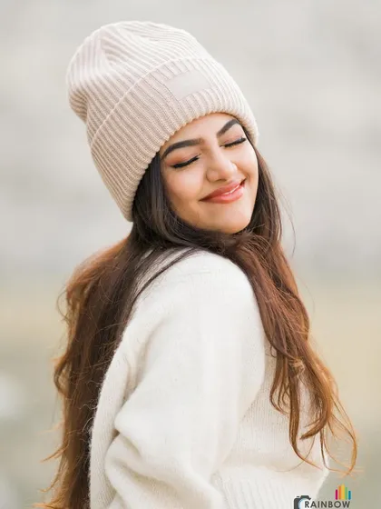 A happy, eyes-closed smile that captures the feeling of warmth and comfort in winter clothing.