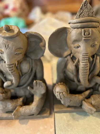 Two unique Ganesha idols sitting side-by-side, each with its own distinct character. I love seeing the different interpretations that come out of the same workshop.
